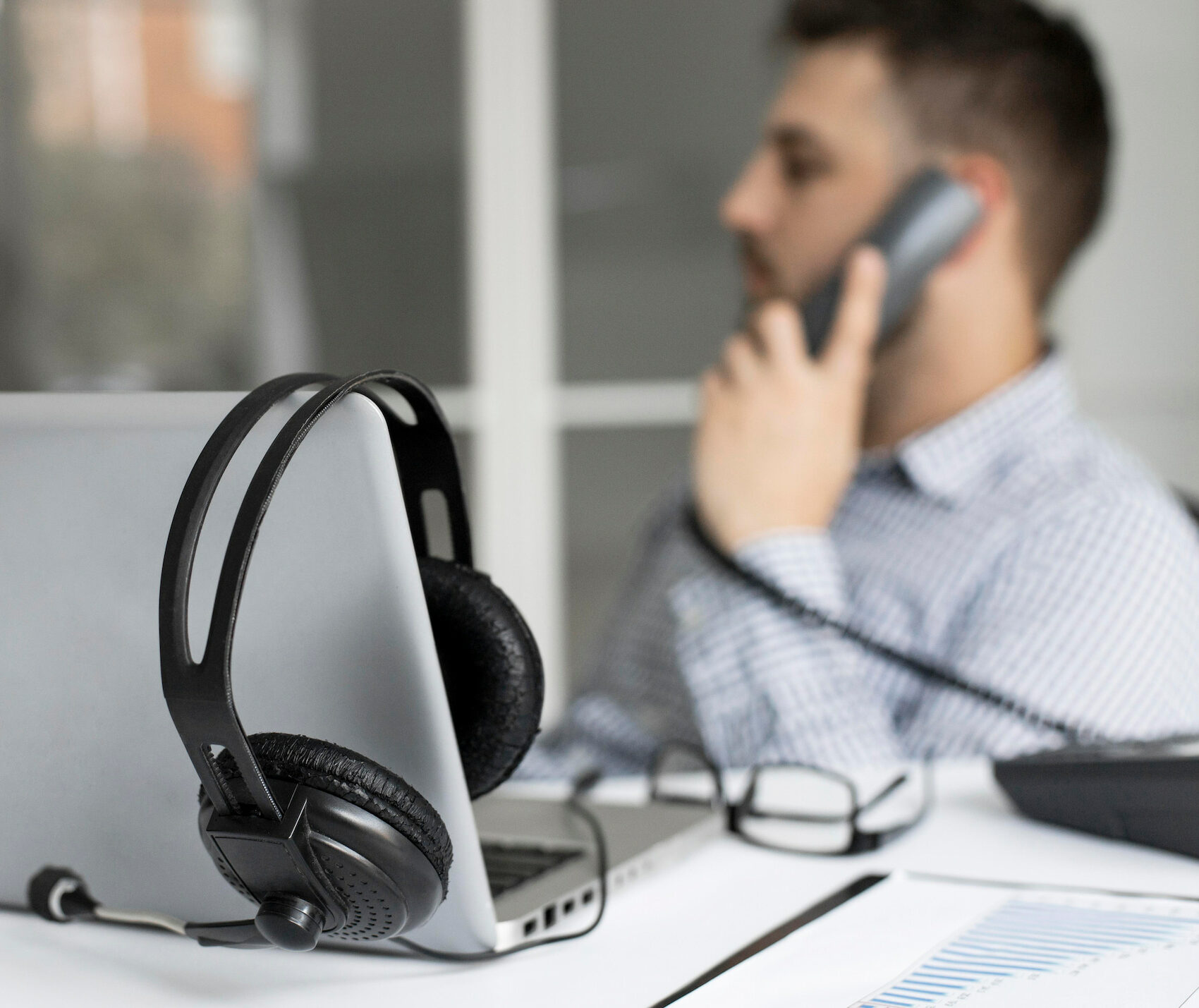 Persona sentada en un escritorio con un portátil, trabajando en telefonía, centralita virtual