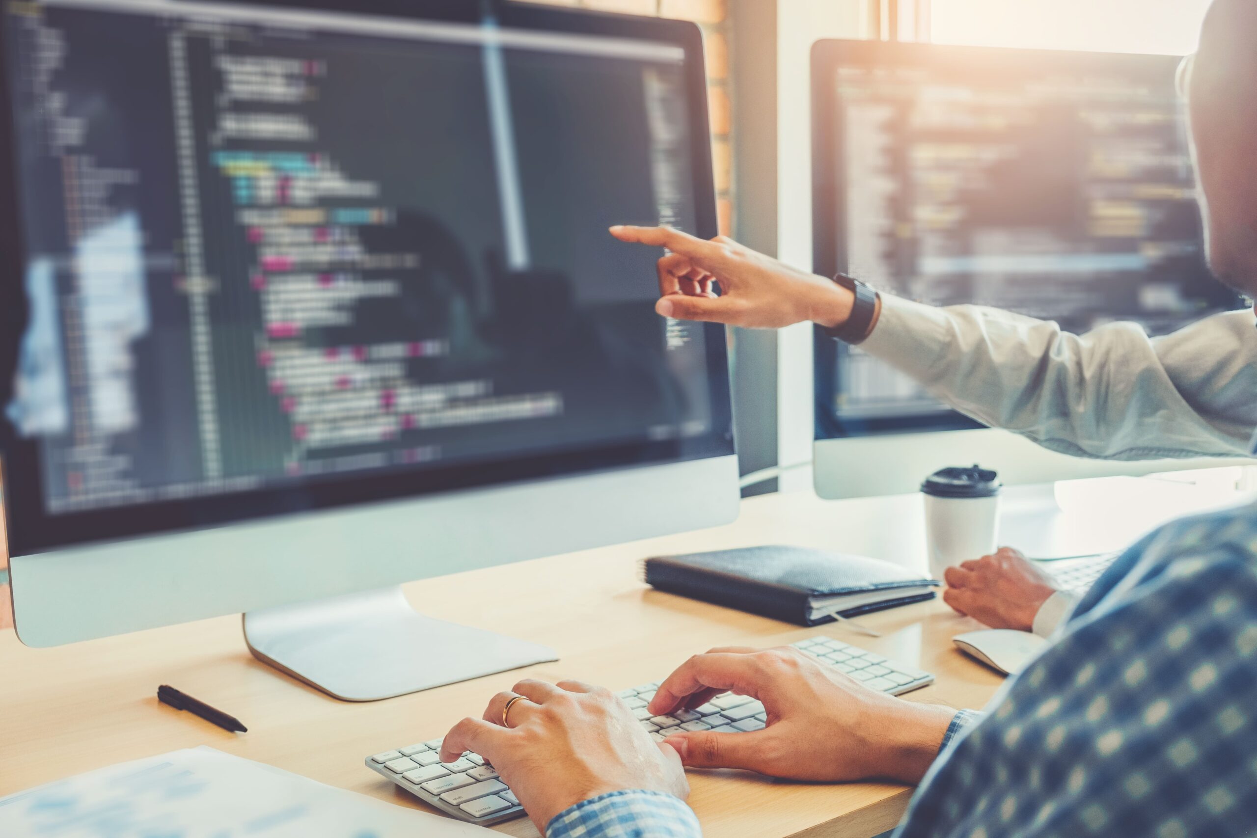 Programadores trabajando en equipo discutiendo alguna implementación del código.