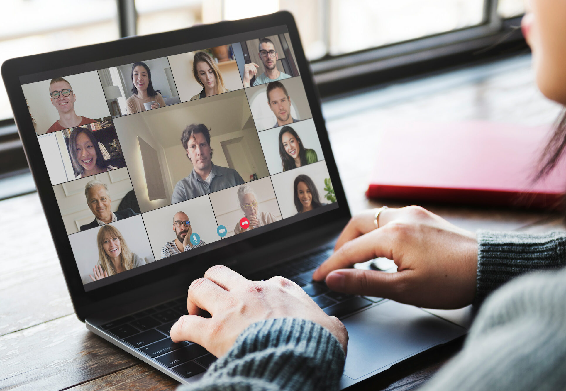 Imagen de una persona participando en una videoconferencia con múltiples participantes a través de un portátil. Integraciones de comunicación.