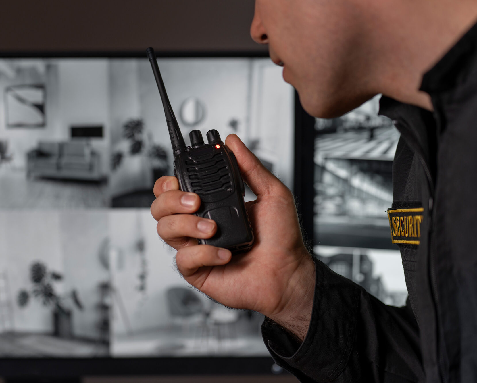 Profesional de seguridad en uniforme comunicándose a través de un walkie-talkie.