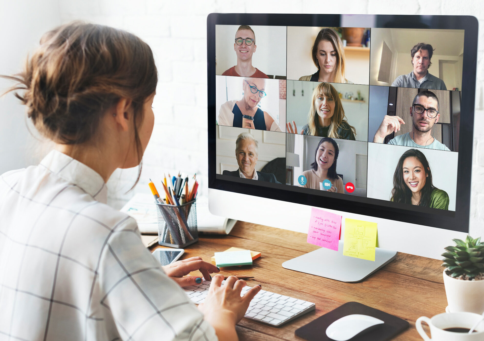 Imagen de una persona de espaldas participando en una reunión virtual con múltiples participantes. Representando integraciones de comunicación.