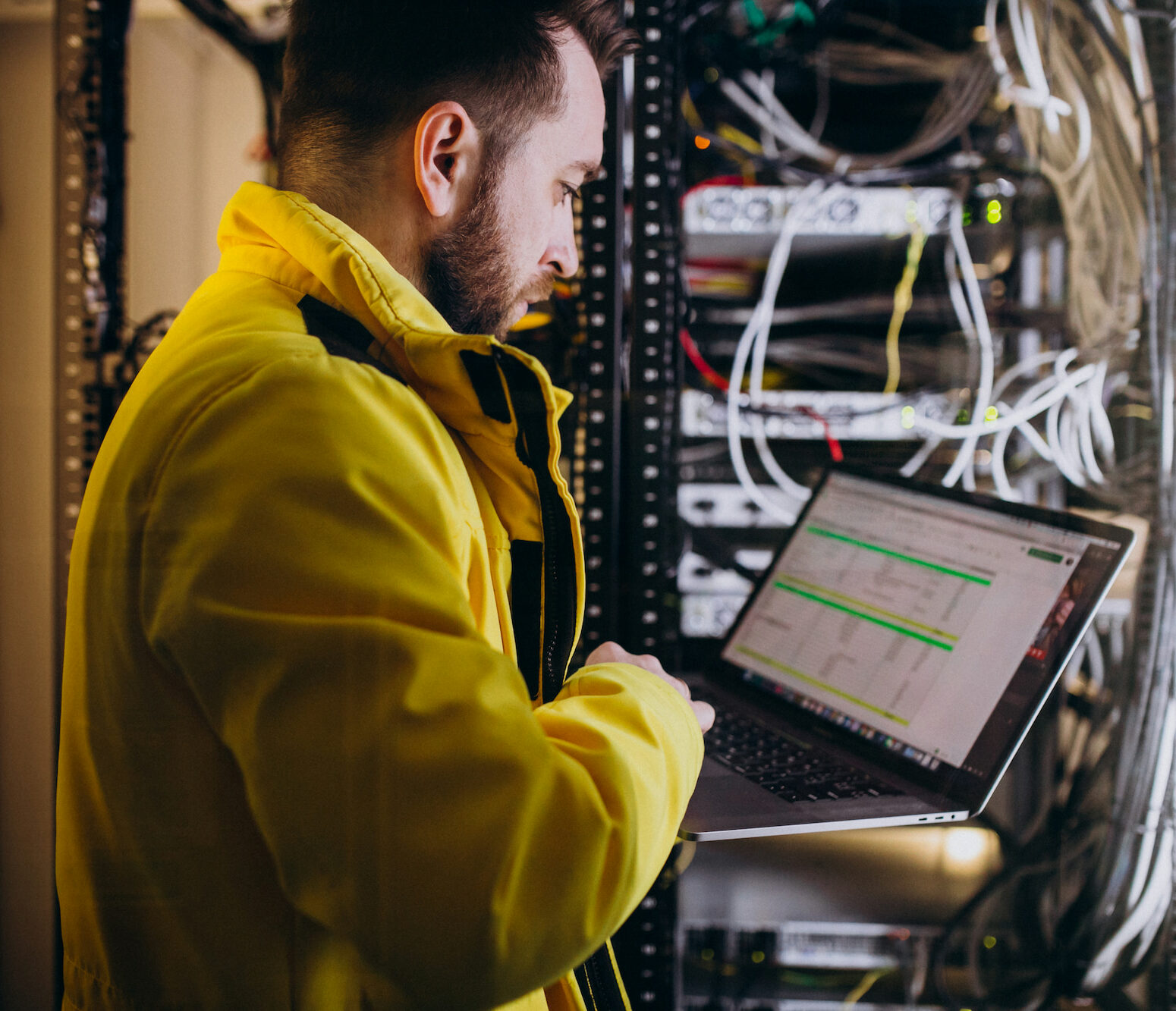 Especialista en TI trabajando en un centro de datos con servidores y cables para la certificación de cableado.